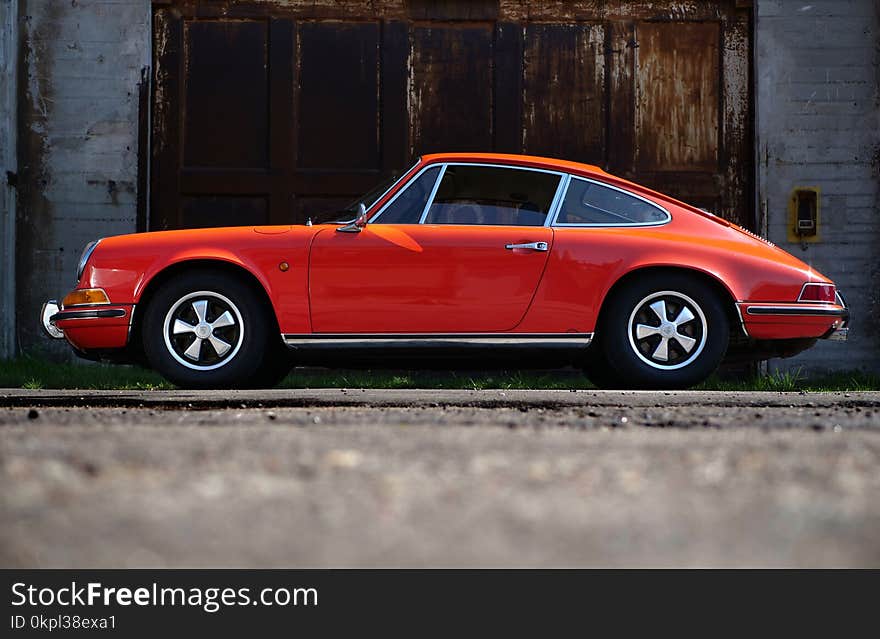 Orange Fastback Car Near Wall