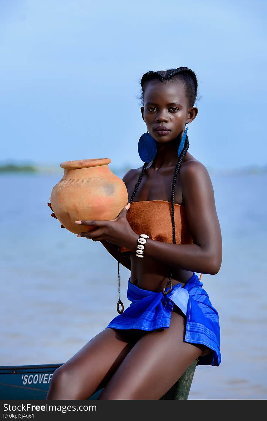 Woman Sitting on Boat Holding Brown Clay Pot