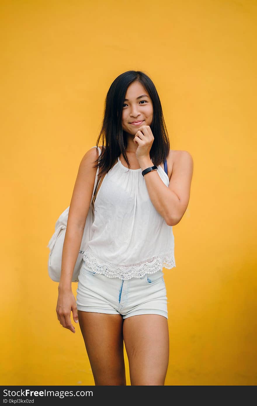 Woman Wearing White Sleeveless Shirt And White Denim Shorts