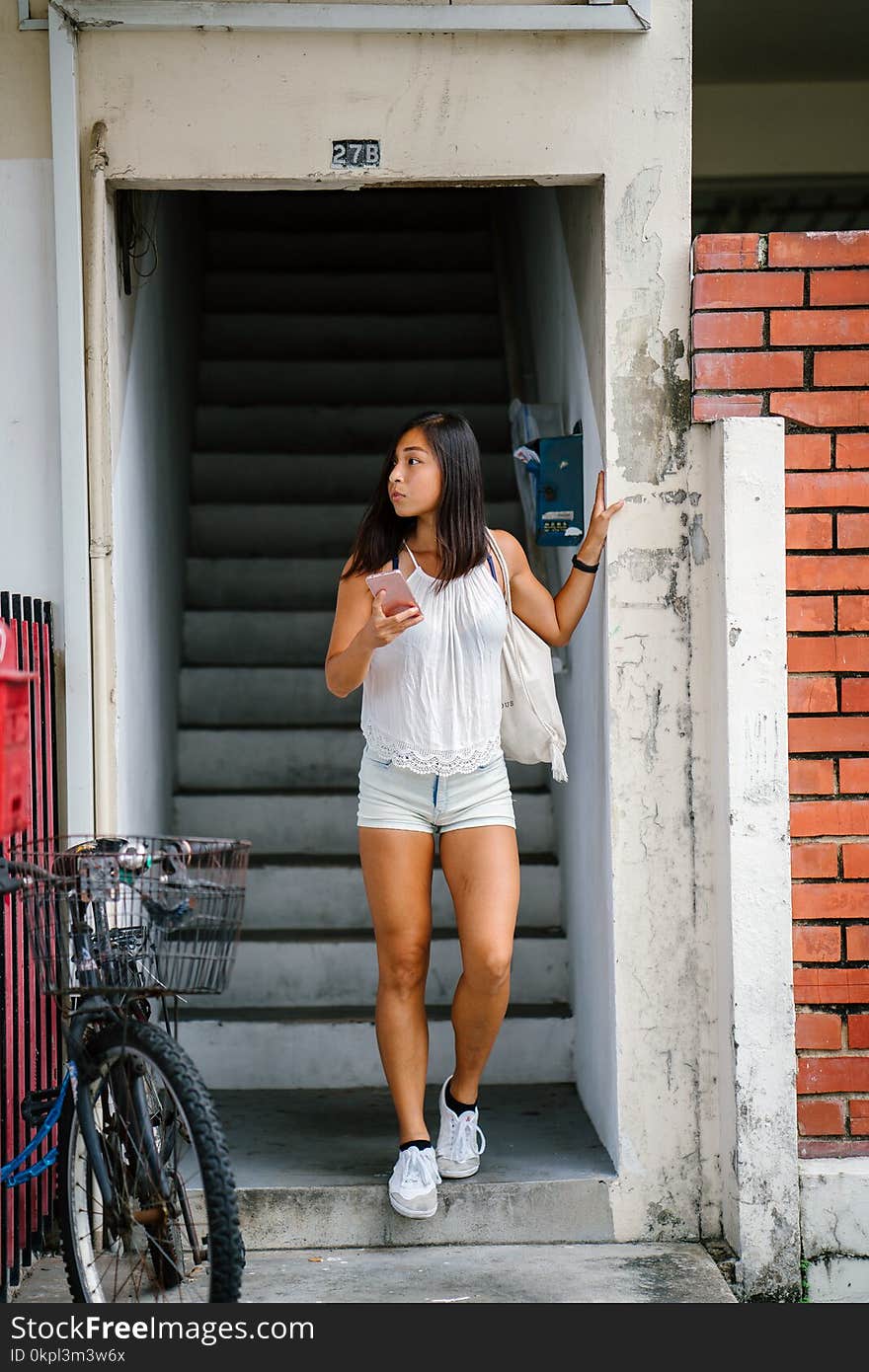 Woman Wearing White Top Holding Smartphone