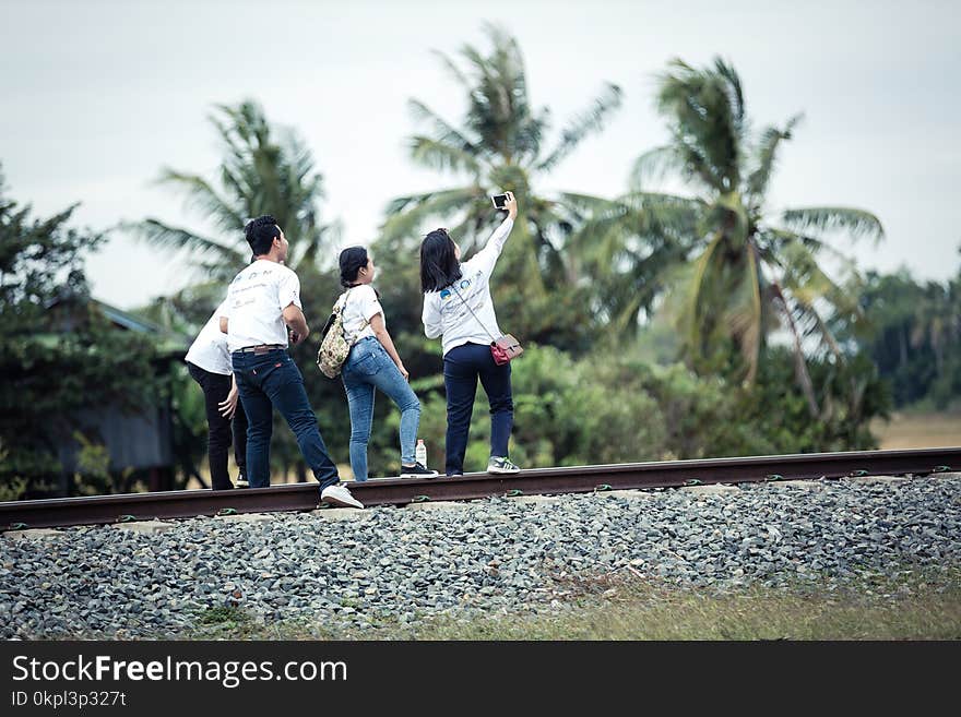 Person Taking a Selfie With Three Persons on Train Railway