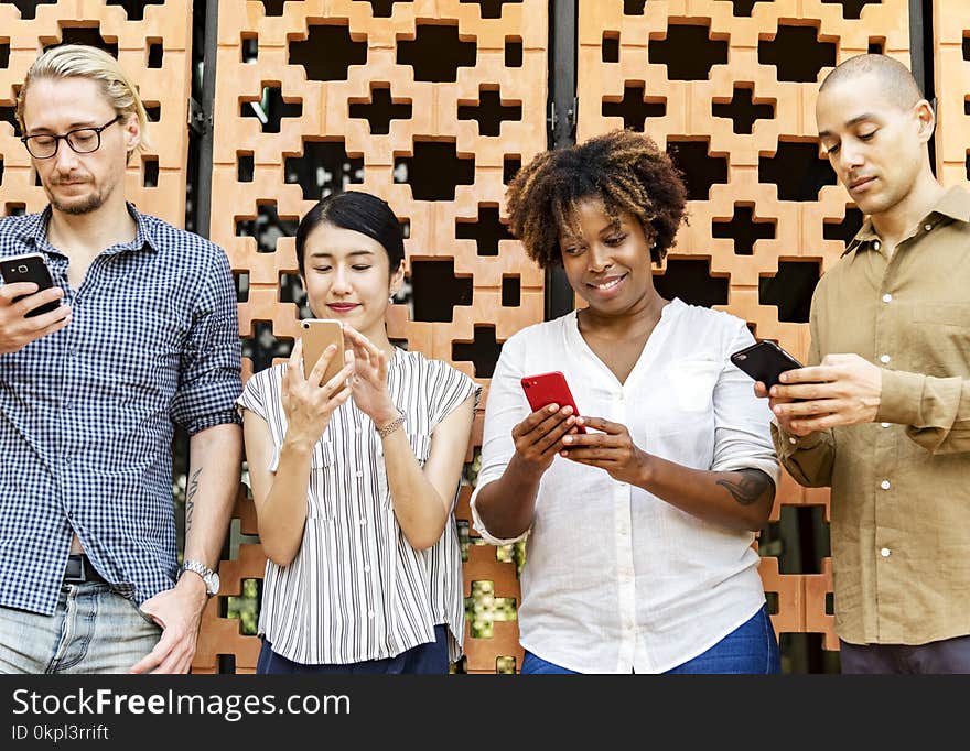 Four People Holding Mobile Phones