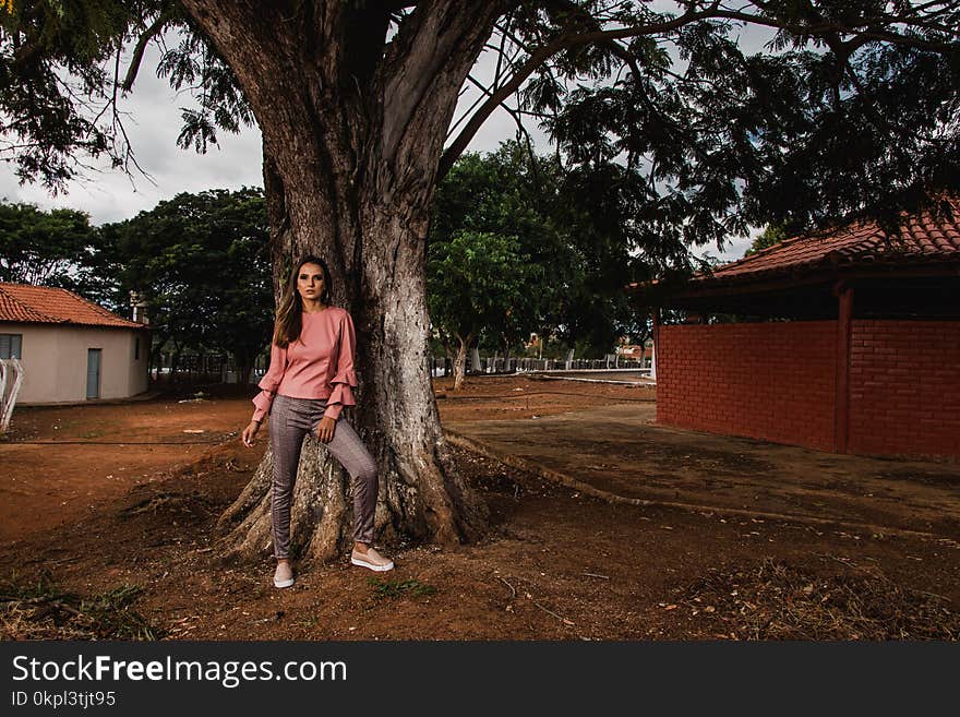 Woman In Pink Long-sleeved Blouse and Grey Pants