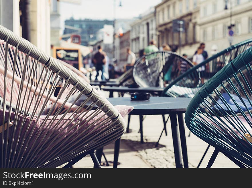 Selective Focus Photography of Patio Set Near Walking People