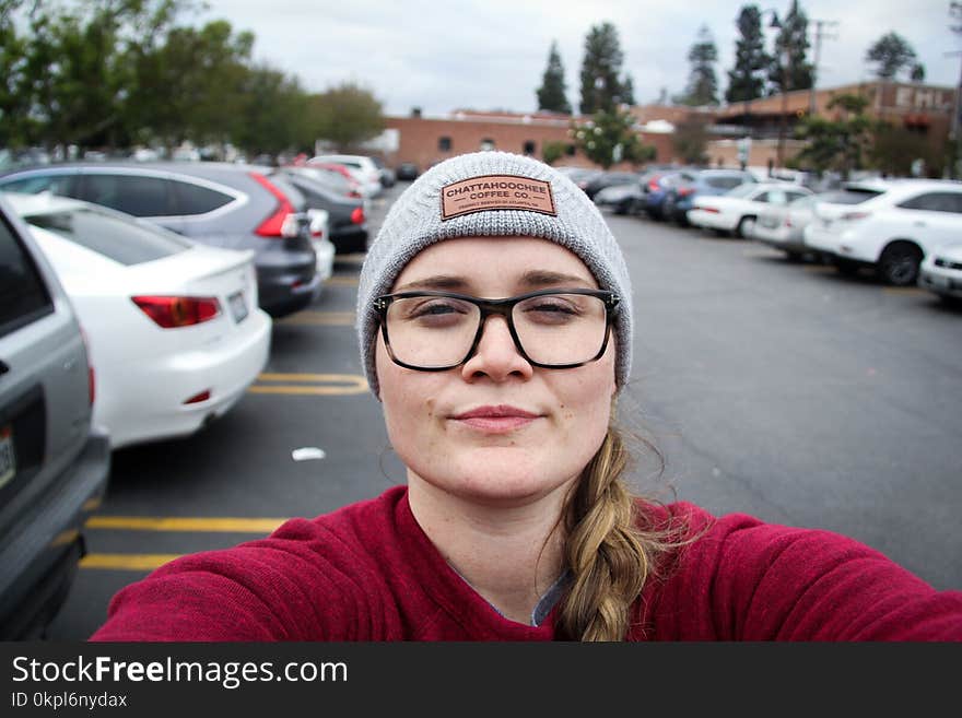 Woman Taking Photo Of Herself Near Parked Vehicles