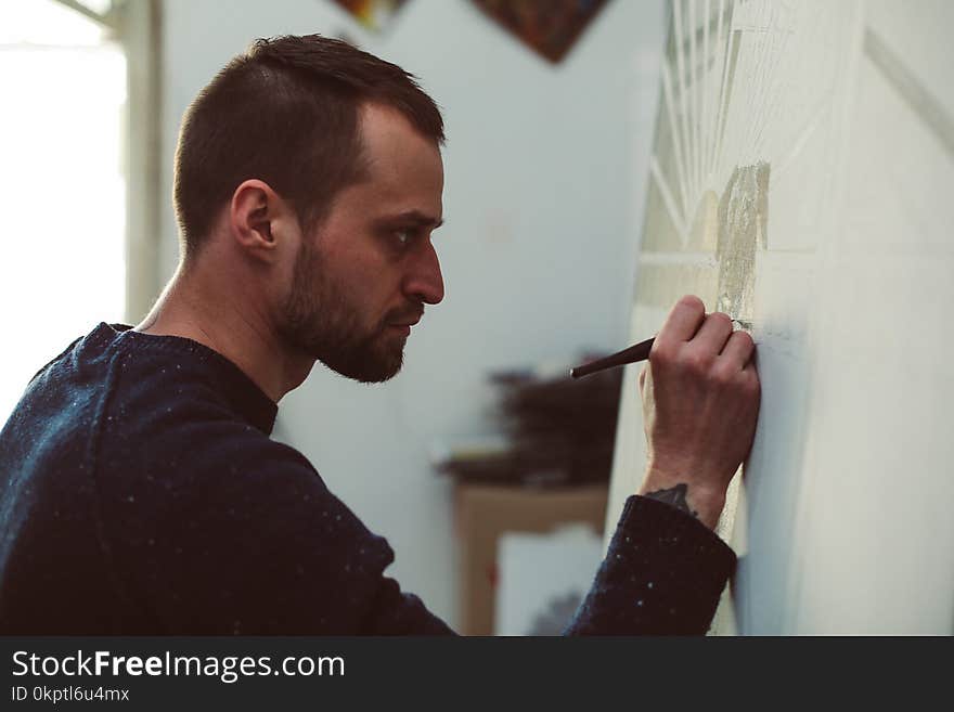 Profile portrait of bearded artist concentrated on the process of drawing. Profile portrait of bearded artist concentrated on the process of drawing