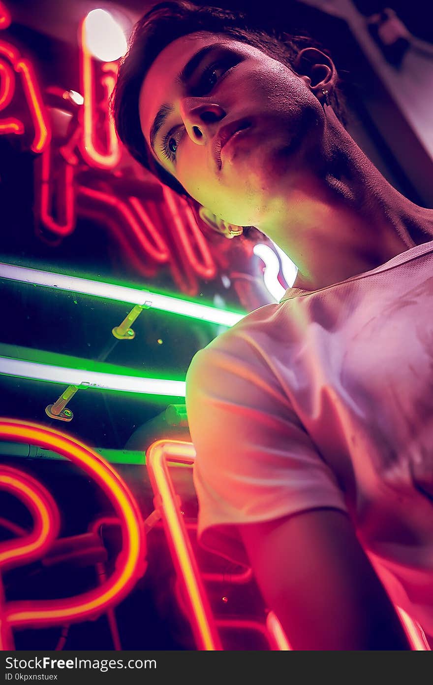 Young Man, Lit By Neon Light At Night.