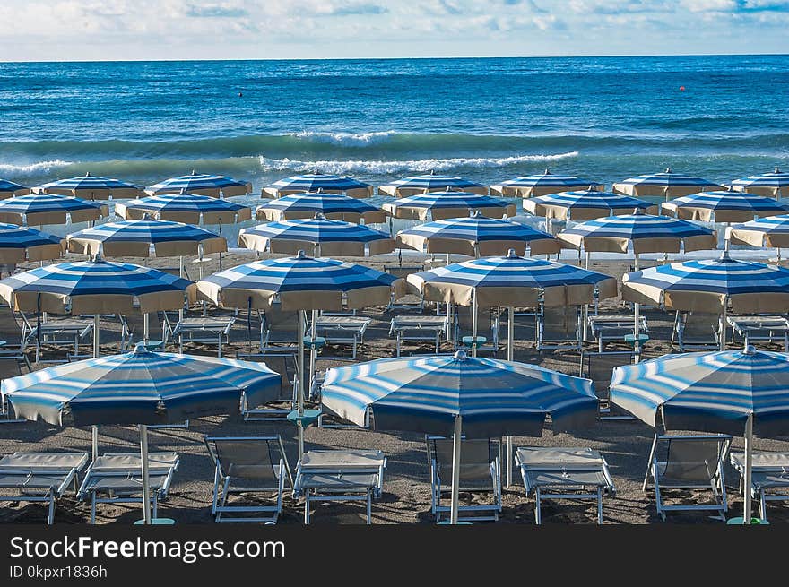 Umbrellas ordered in the beach waiting for the swimmers