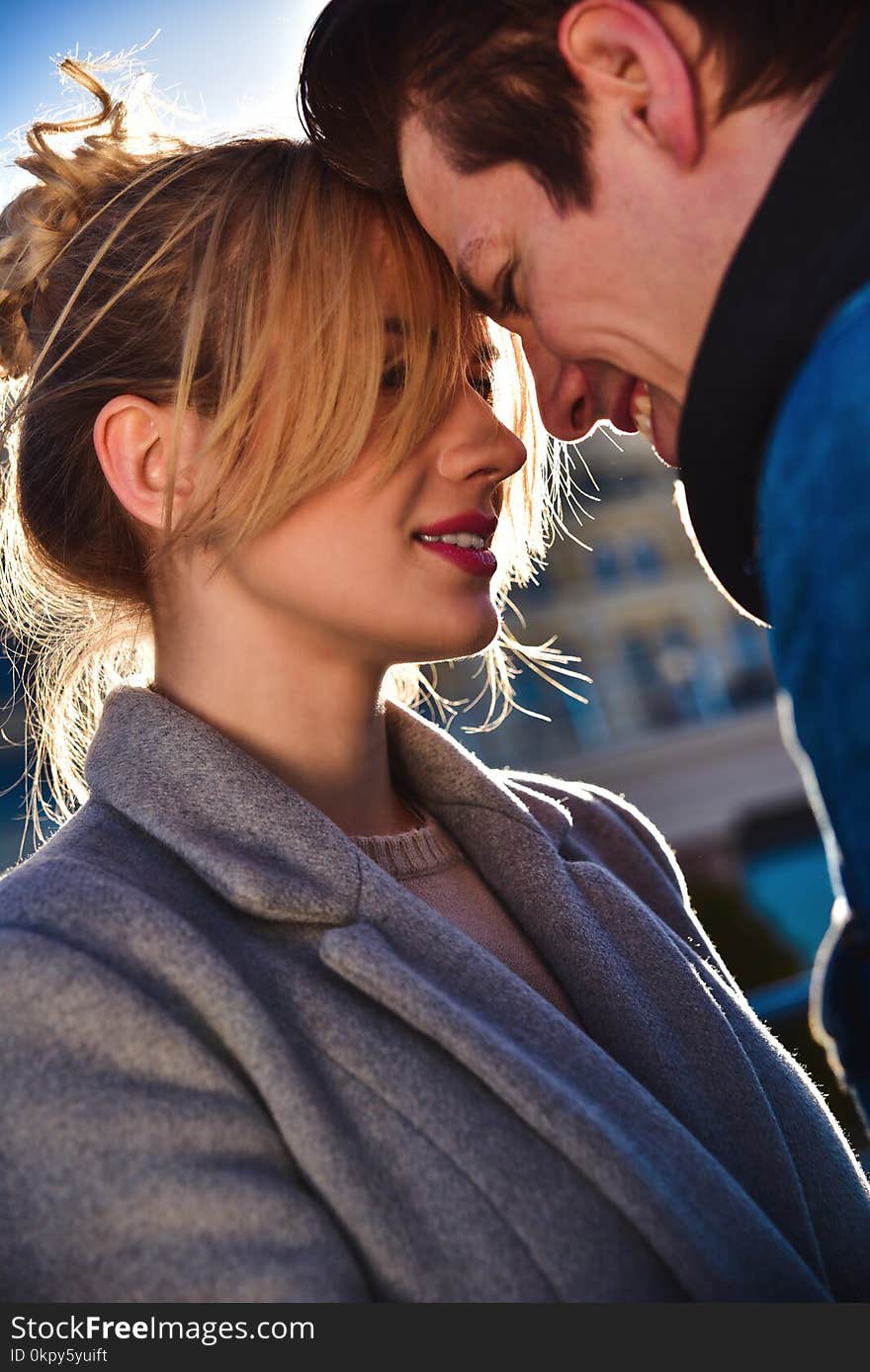 Happy playful couple in sunglasses in love dating joking and laughing in the street. Happy playful couple in sunglasses in love dating joking and laughing in the street