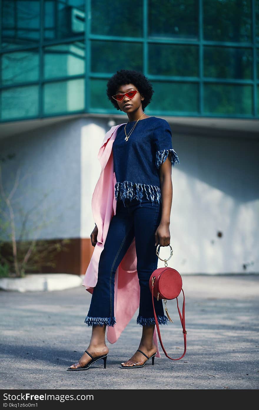 Shallow Focus Photography of Woman in Blue Clothes Holding Red Leather 2-way Handbag