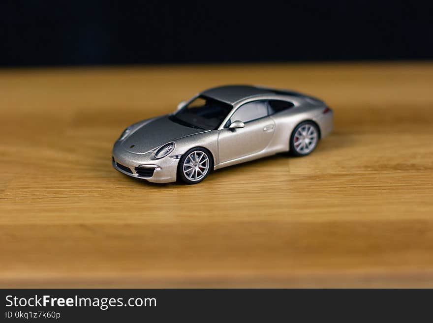 Shallow Focus of Silver Die-cast Model on Brown Wooden Board