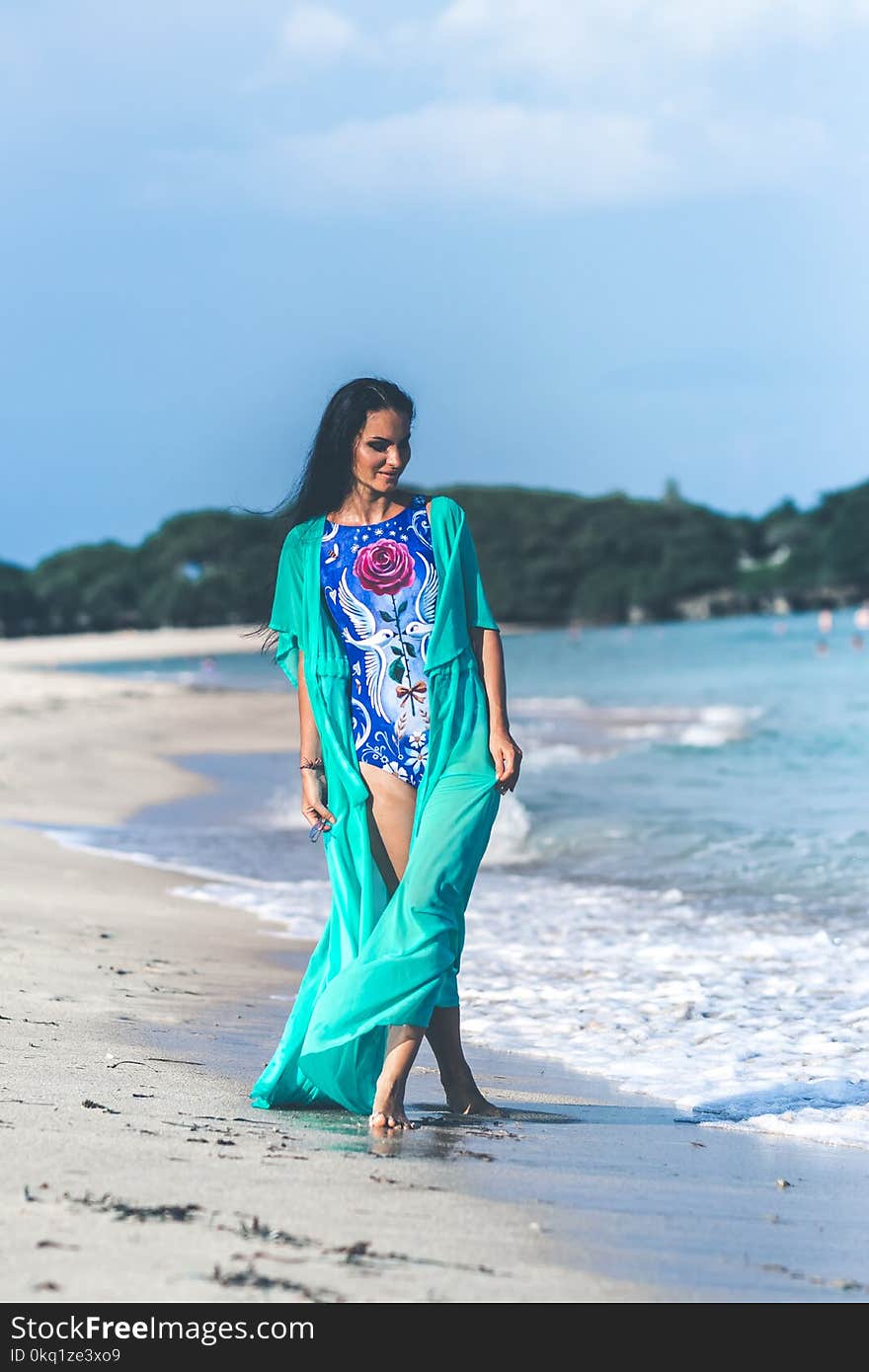 Woman in Blue and Pink Floral Monokini Standing at the Seashore