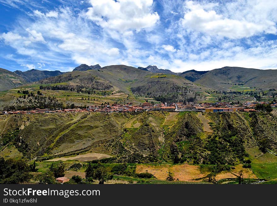 Birdseye Photography of Buildings Near Hills and Trees Under Blue Sky