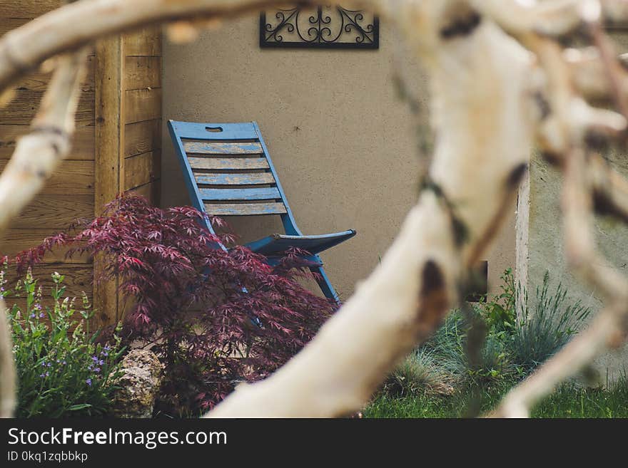 Blue Wooden Chair Near Brown Wooden Wall