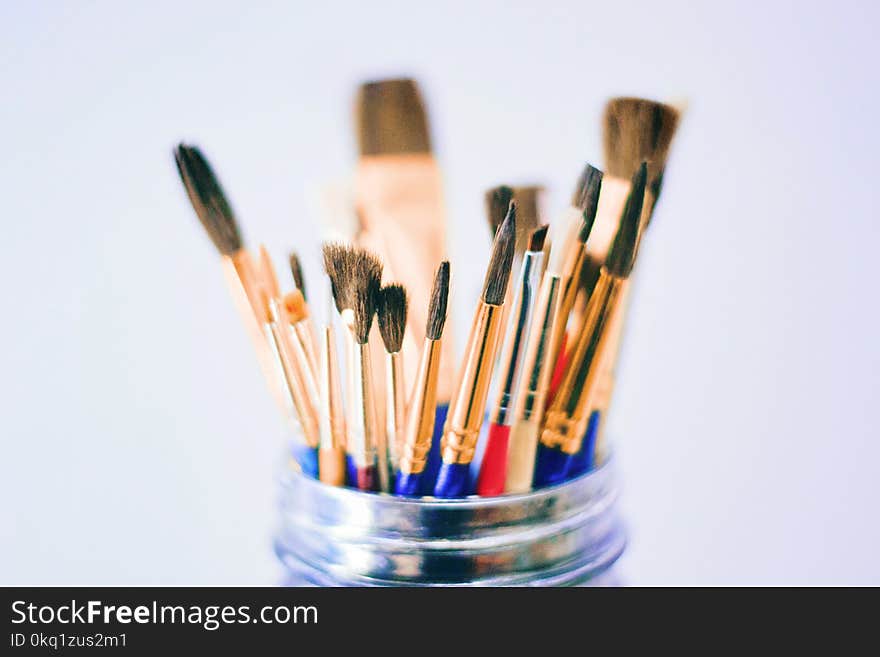 Shallow Photography of Brushes on Jar