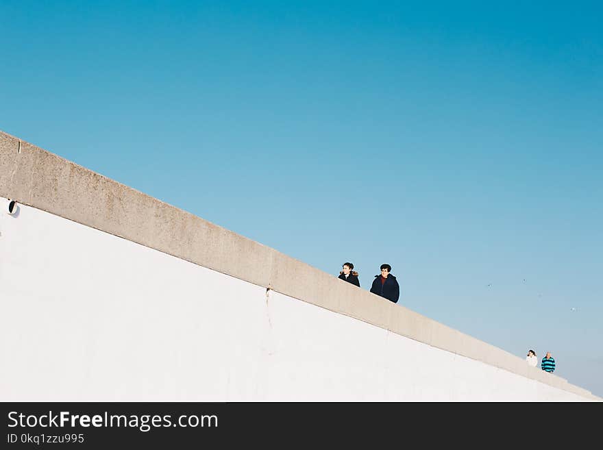 Four Person Wearing Jacket Under White Cloud Blue Skies