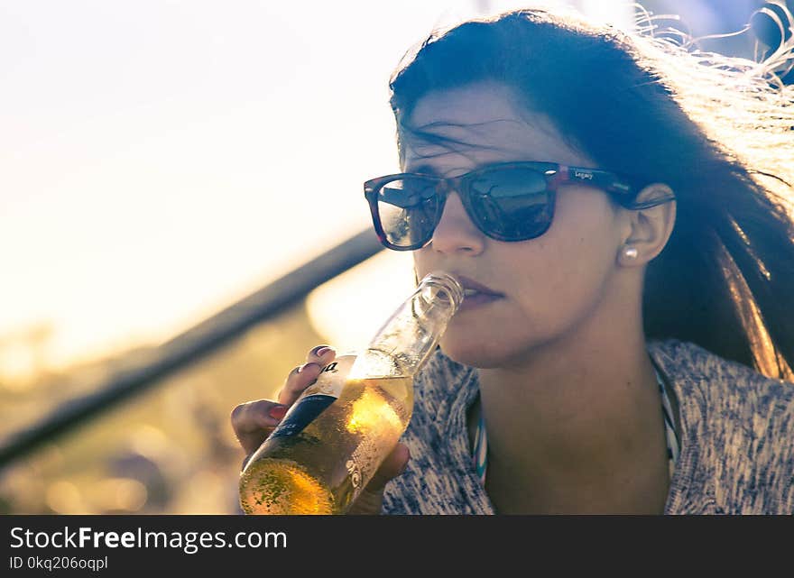 Woman Drinking Beverage on Bottle