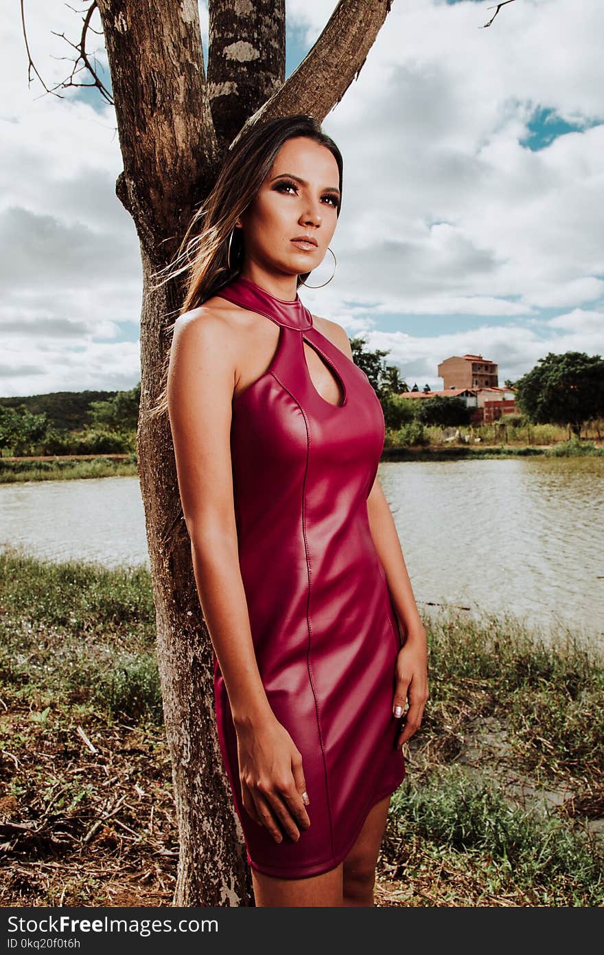 Woman Wearing Red Sleeveless Dress Standing Near Tree