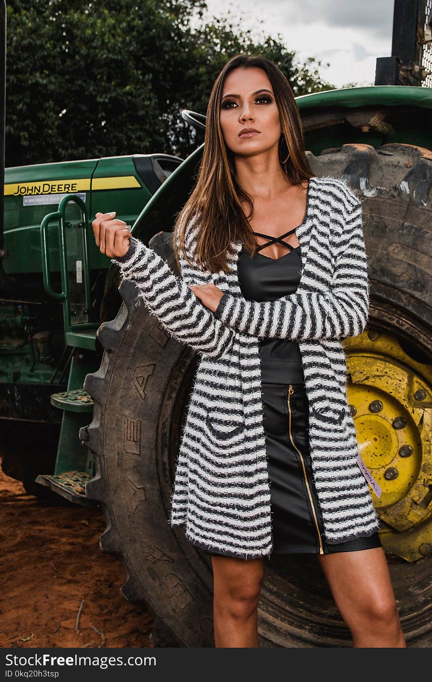 Woman Wearing Pink and Black Striped Long Cardigan Standing Behind John Deere Tractor at Daytim E