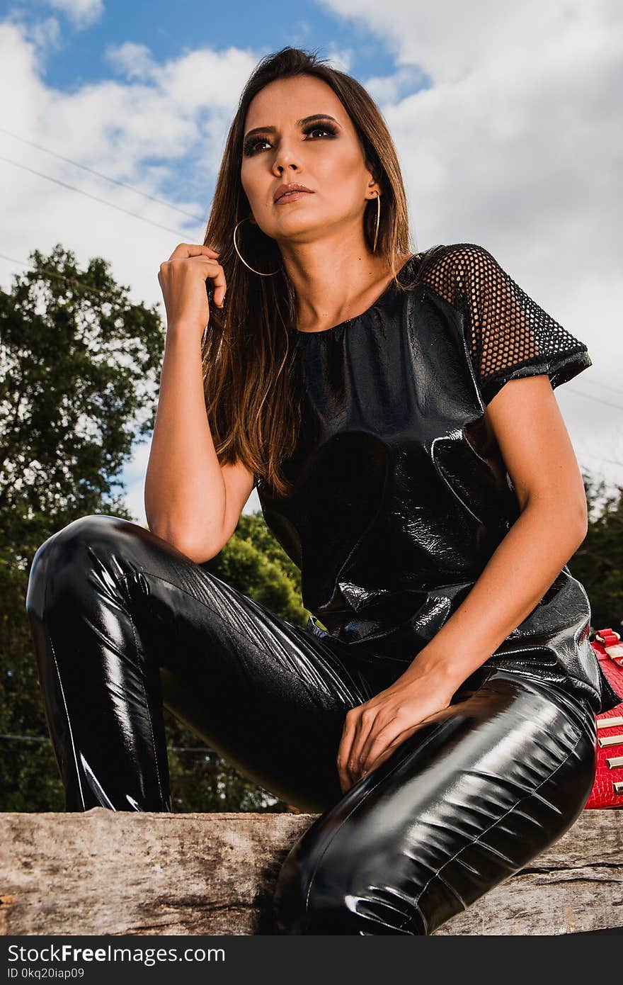 Woman in Black Leather Pants Sitting on Log