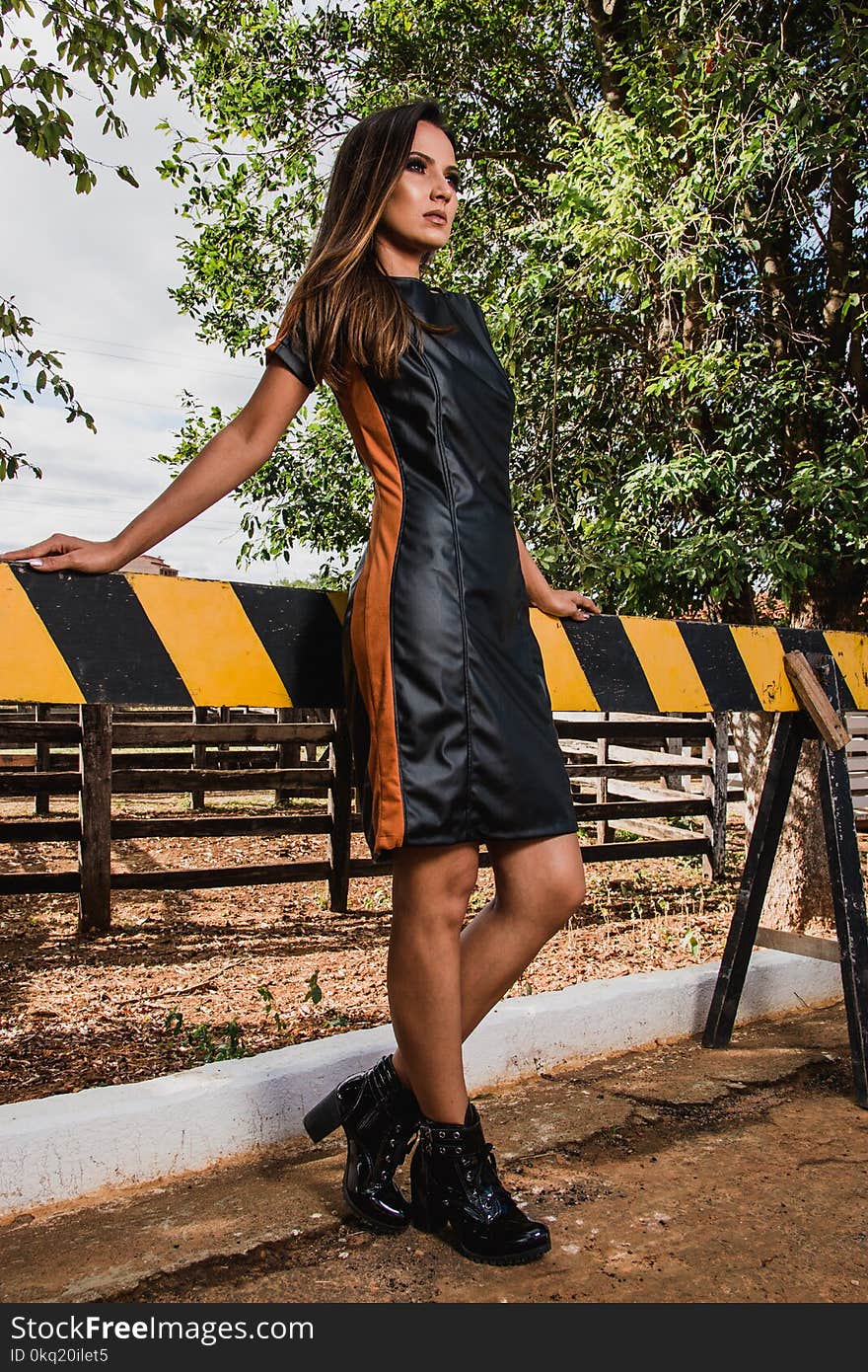 Woman Wearing Black and Brown Leather Midi Dress and Black Chunky Heeled Boots