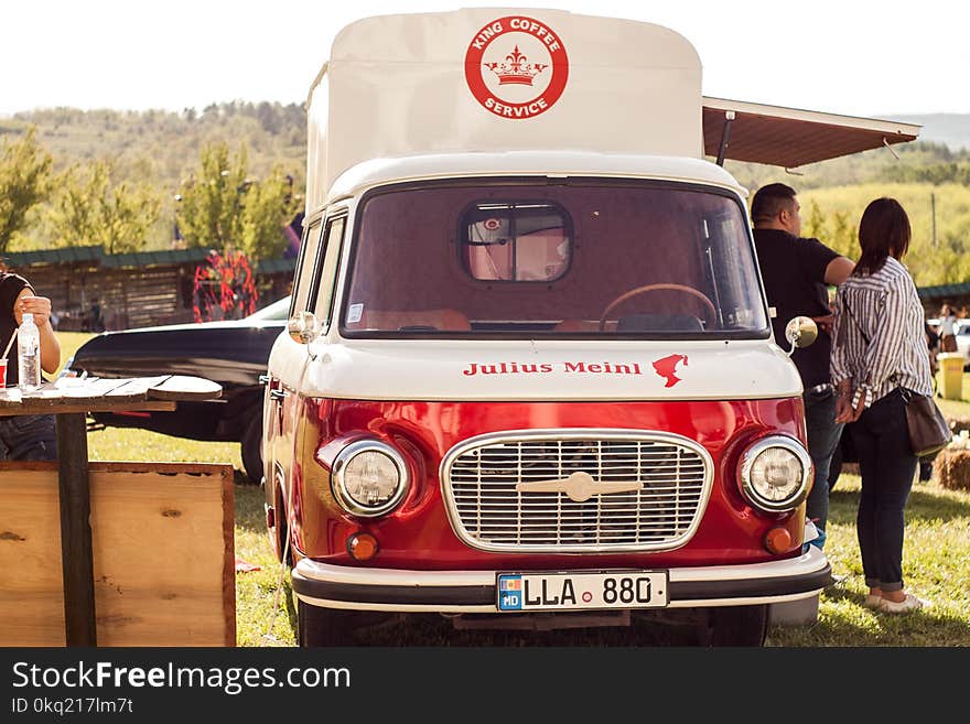 People Standing Beside of Red and White Van