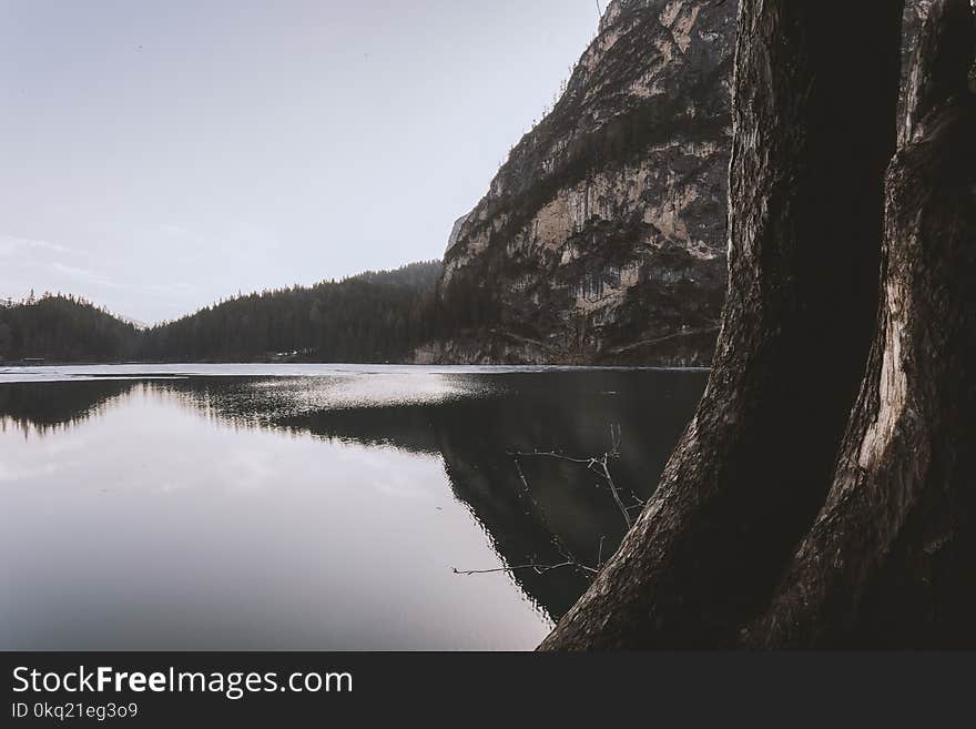 Landscape Photography of Lake Beside Cliff at Daytime