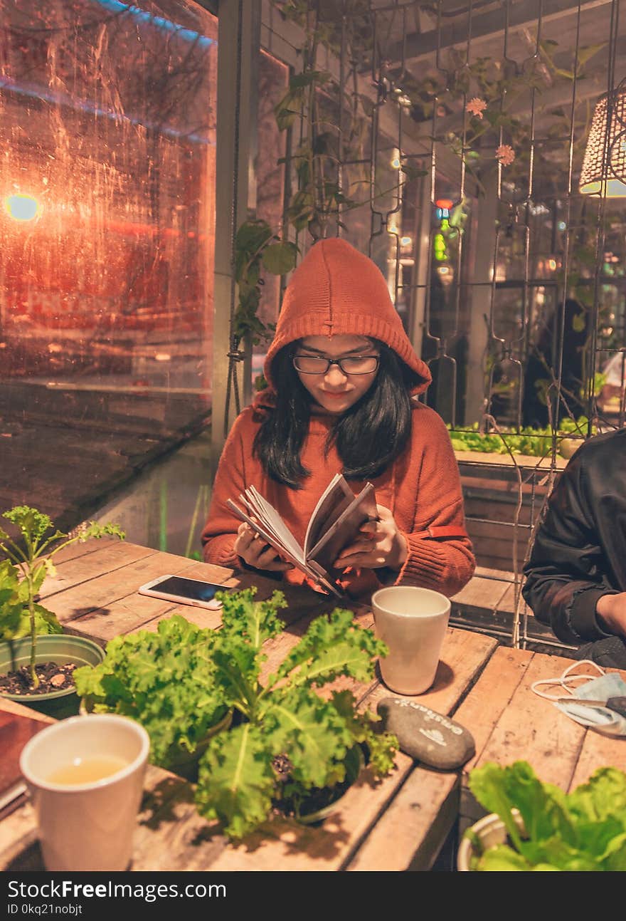 Woman Wearing Red Jacket While Reading Book