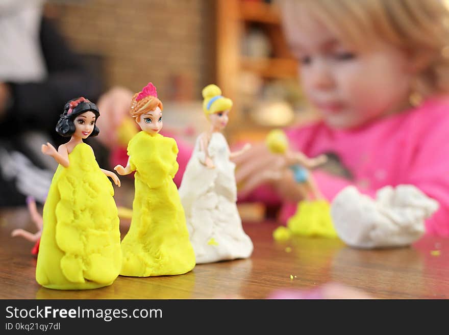 Selective Focus Photography of Three Disney Princesses Figurines on Brown Surface