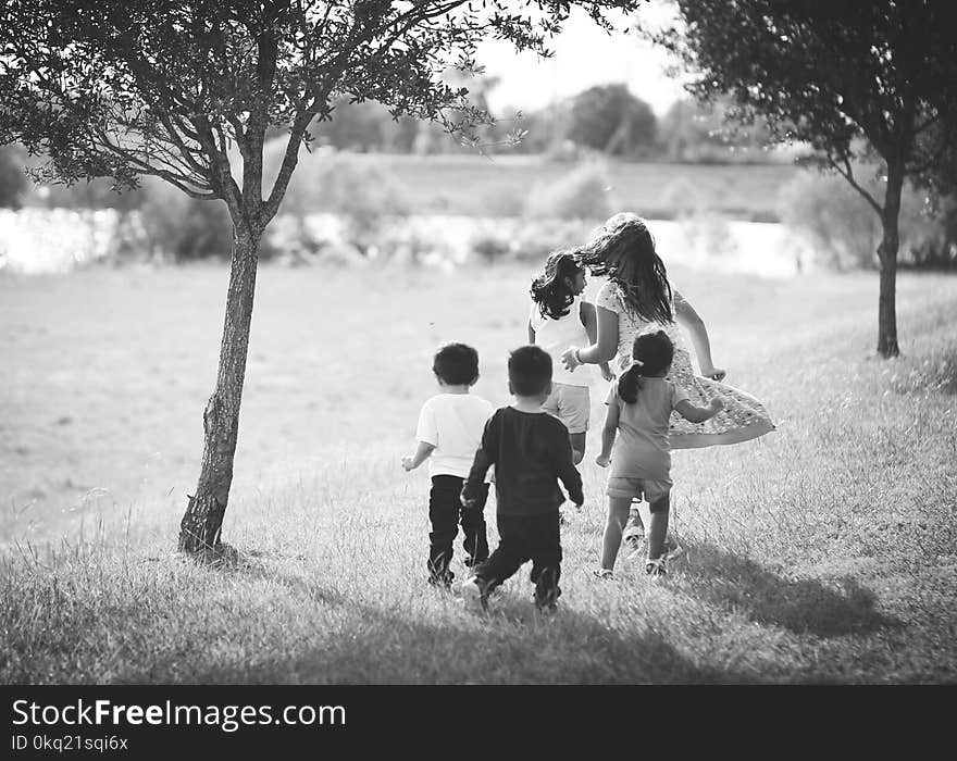 Grayscale Photo of Five Children Near Tree