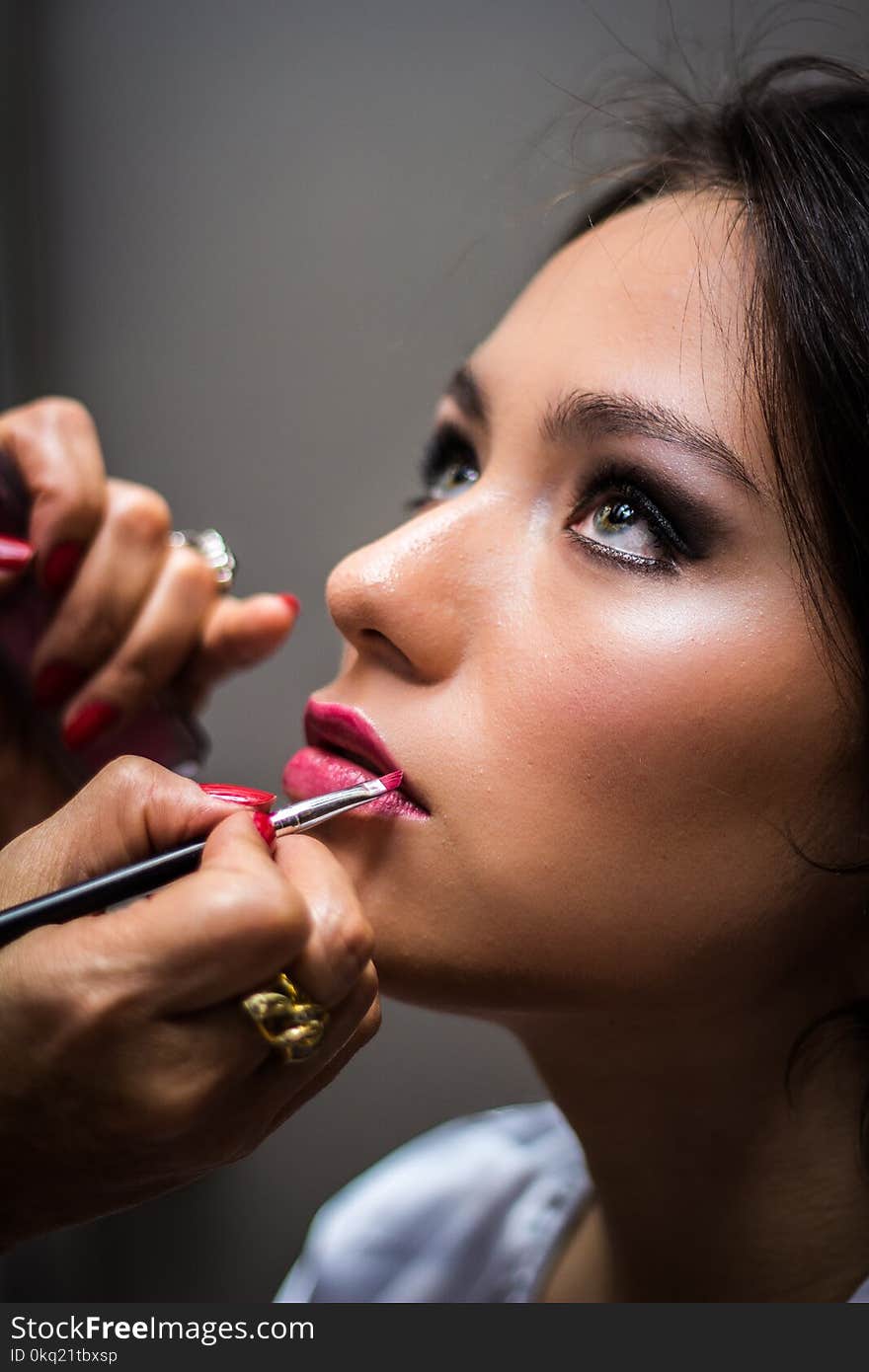 Woman Putting Lipstick on Her Lips