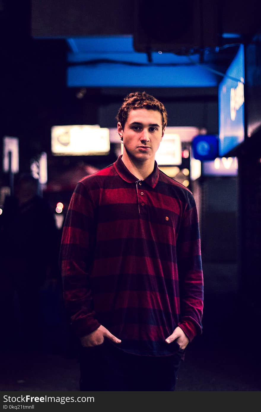 Man Wearing Red and Maroon Striped Long-sleeved Polo Shirt Holding Pockets