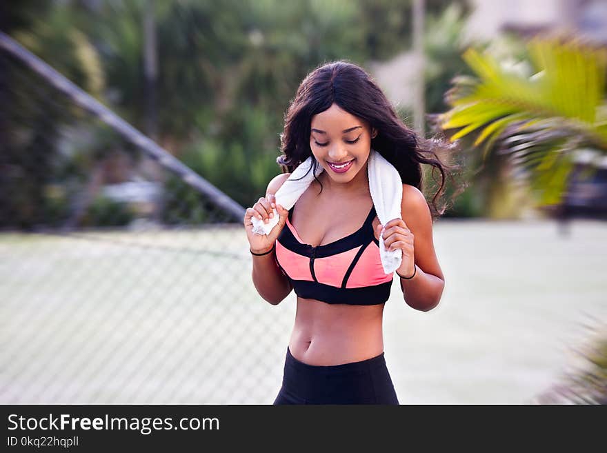 Woman Wearing Pink and Black Sports Bra Holding Towel