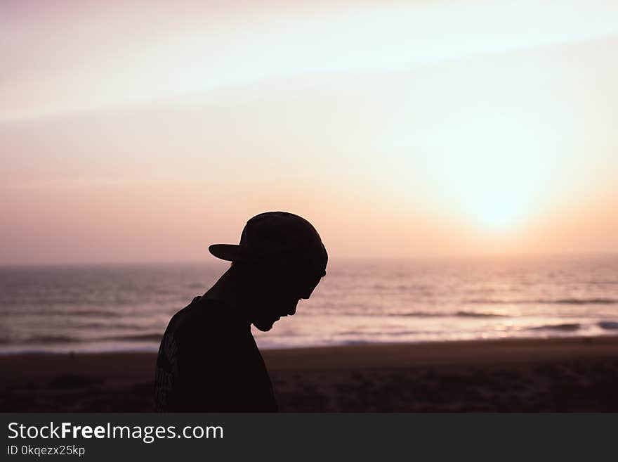 Silhouette of Man Wearing Cap at the Beach