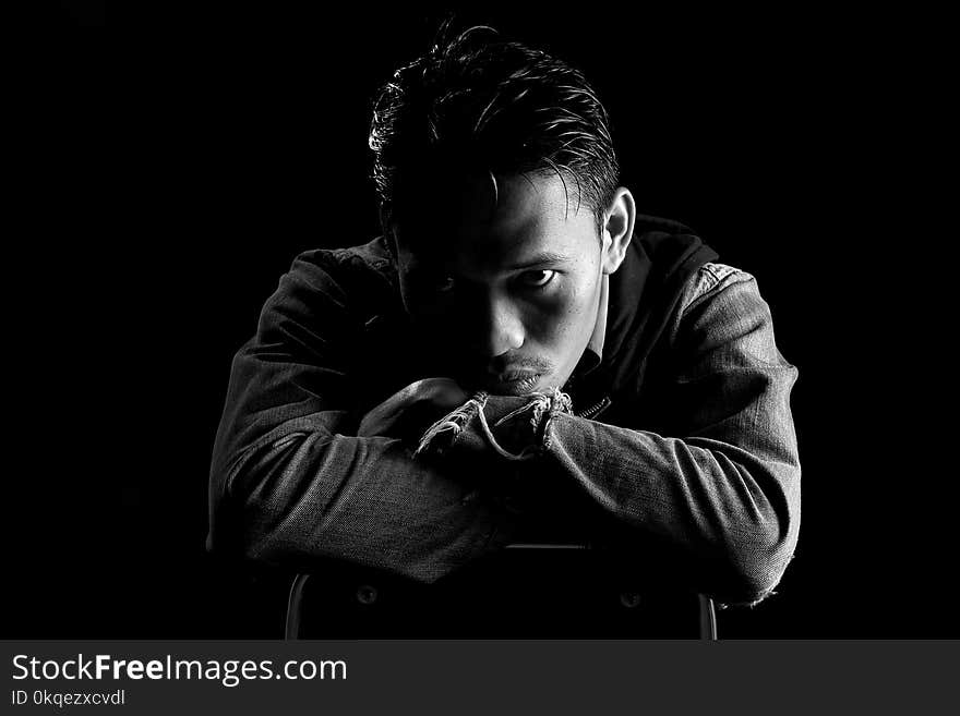 Grayscale Photo of Man Wearing Dress Shirt Sitting on Chair