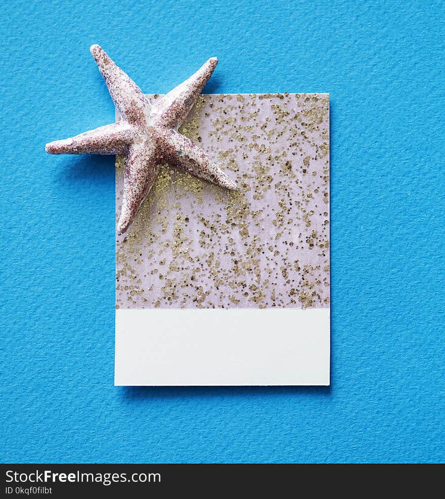 Gray Starfish and White and Gray Paper on Blue Surface