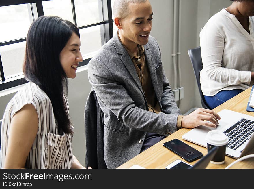 Photo of Man and Woman Looking at Laptop