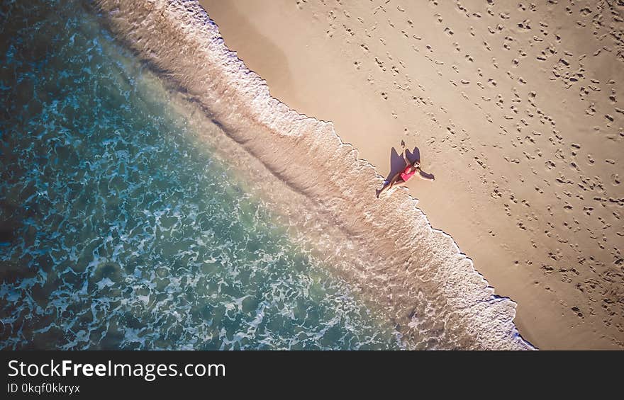 Photo of Person Lying Beside Seashore