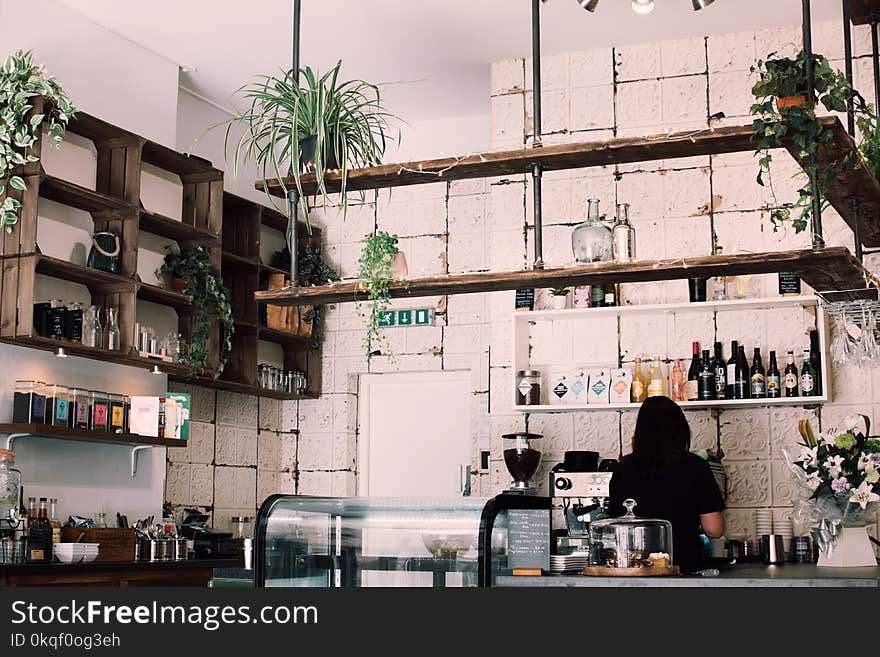 Woman Beside Bottles and Cupboard