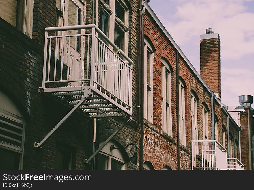 Closeup Photo of Brown Building With Fire Exit Ladder