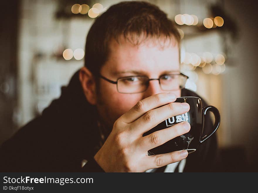 Man in Black Jacket Holding a Mug