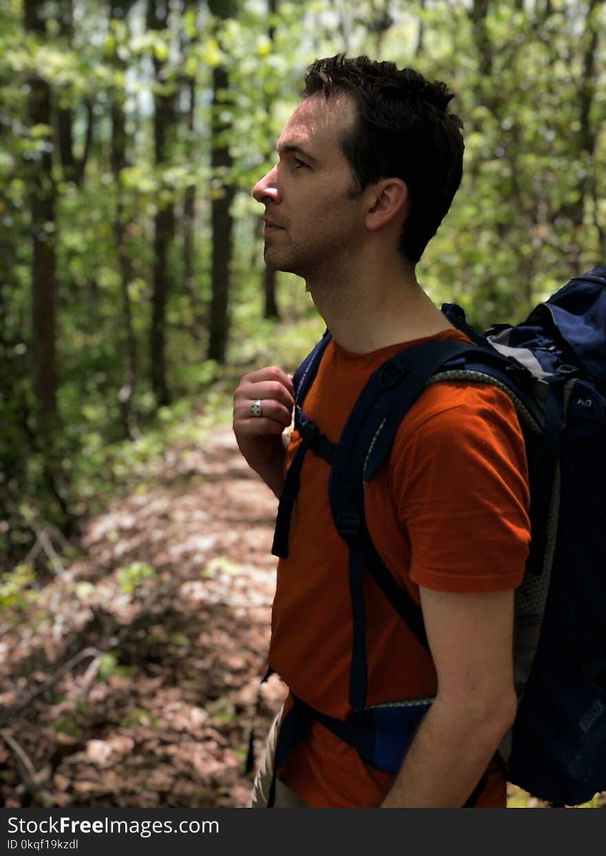 Man in Red Crew-neck Shirt Carrying Blue Hiking Backpack