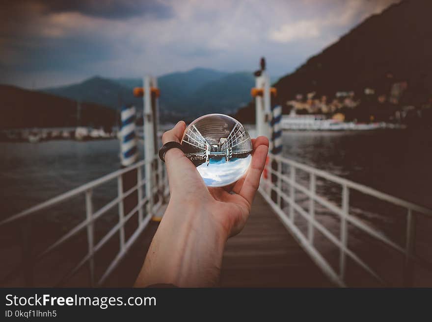 Person Holding Clear Glass Ball