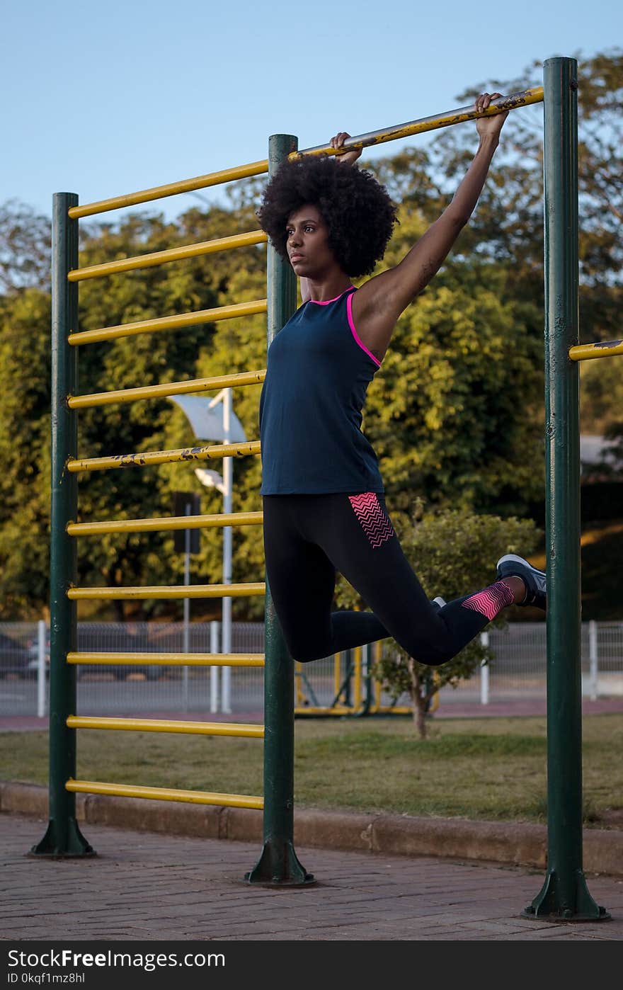 Woman Hanging on Climb Bar on Park