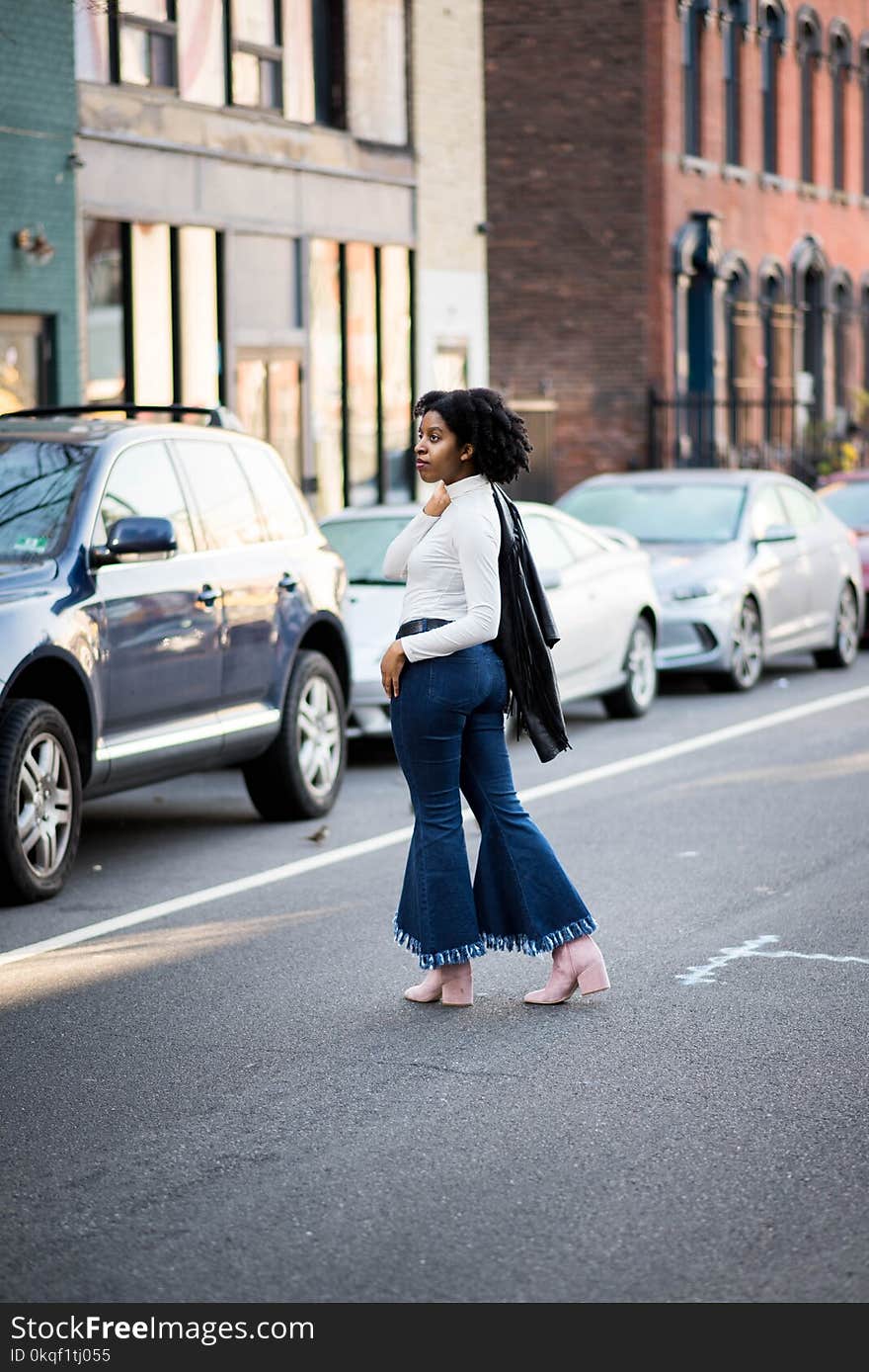 Women&#x27;s in White Long-sleeved Top and Blue Flared Jeans