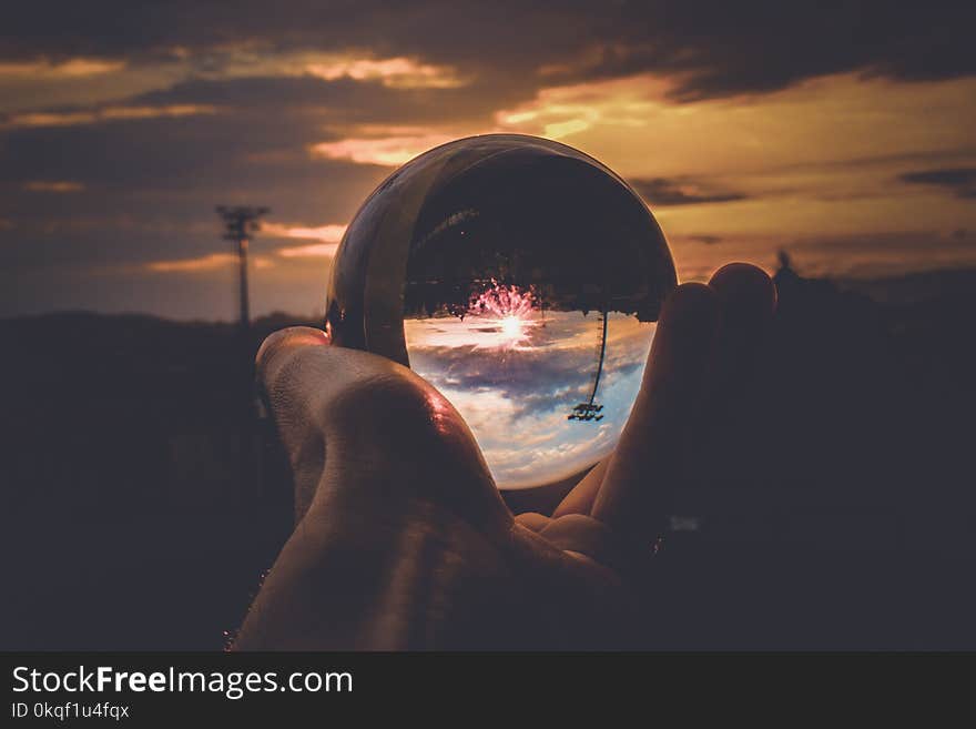 Person Holding Clear Glass Ball