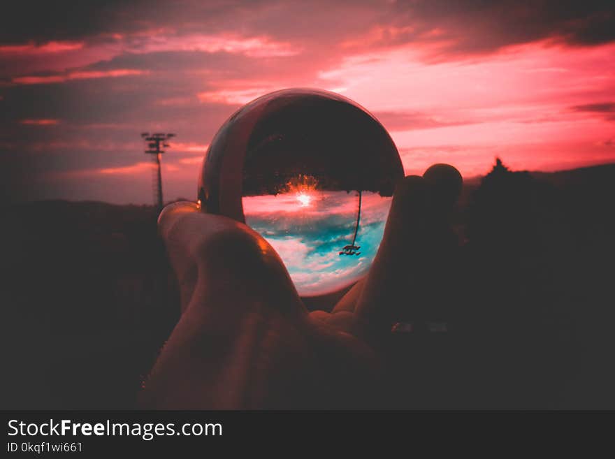 Person Holding Round Clear Glass Decor