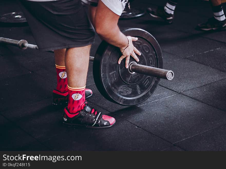 Person Holding Black Weight Plate