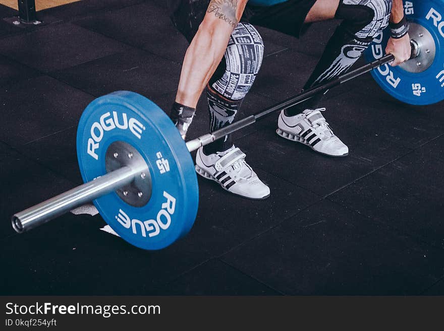 Man With Lift Stance Holds Blue Rogue Adjustable Barbell