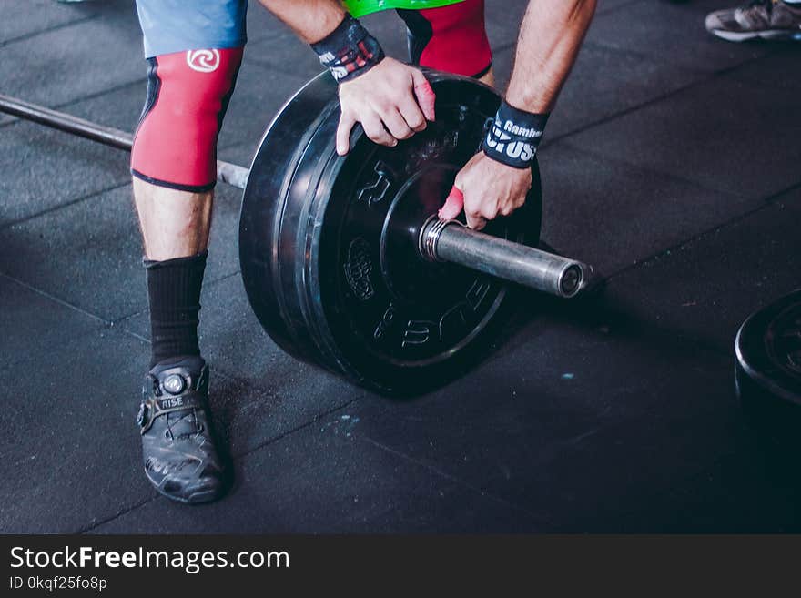 Person Holding Black Bumper Plate